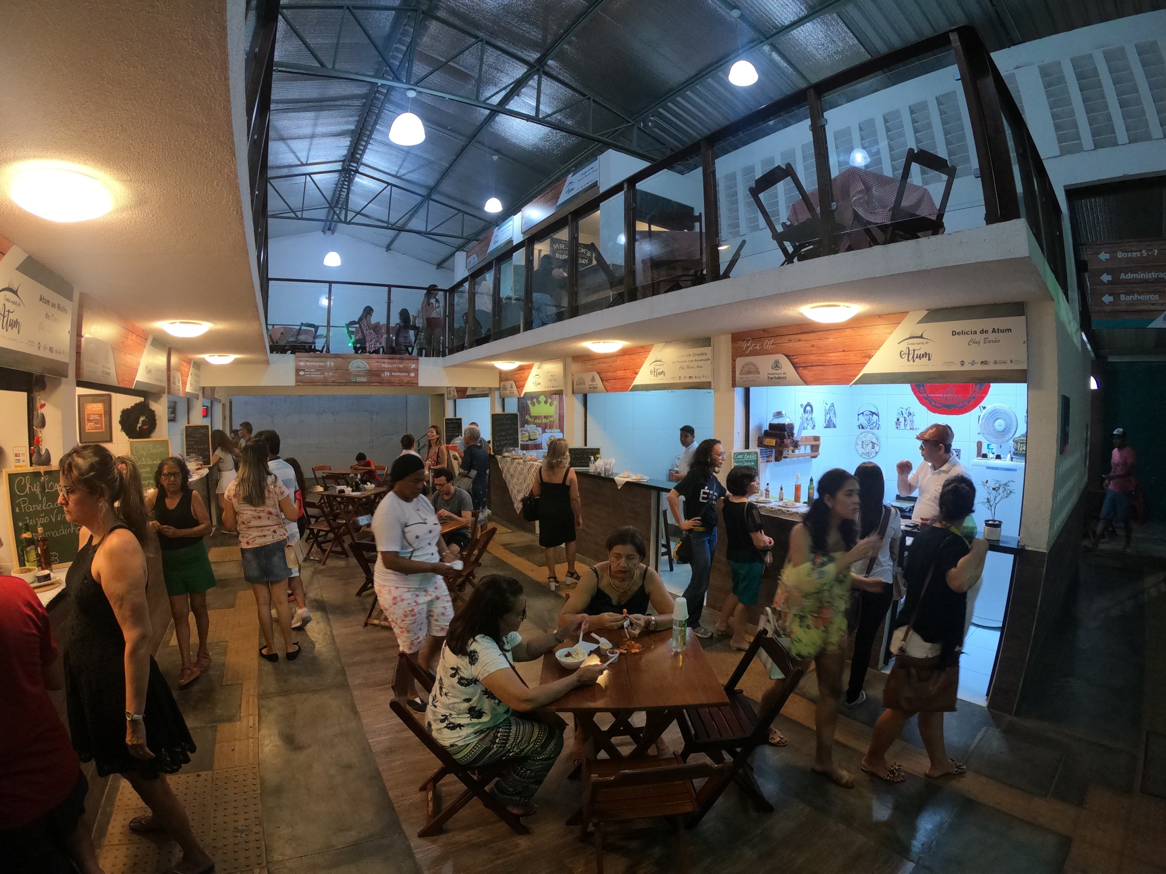 Pessoas sentadas à mesa no Mercado Cultural dos Pinhões